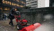 A building worker uses a snowblower to clear sidewalks in the Financial District in Manhattan, New York on December 2, 2019. Scott Heins / Getty Images / AFP