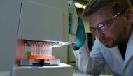 Employee Philipp Hoffmann, of German biopharmaceutical company CureVac, demonstrates research workflow on a vaccine for the coronavirus (COVID-19) disease at a laboratory in Tuebingen, Germany, March 12, 2020. Reuters/Andreas Gebert