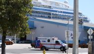 An ambulance takes a patient from the cruise ship Coral Princess to the hospital as the ship is docked at the Port of Miami, Florida, on April 4, 2020, after receiving permission from the US Coast Guard. / AFP / CHANDAN KHANNA