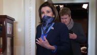 House Speaker Nancy Pelosi (D-CA) wears a scarf over her mouth and nose to guard against the coronavirus as she and her Deputy Chief of Staff Drew Hammill leave a news conference with Minority Leader Charles Schumer (D-NY) at the U.S. Capitol April 21, 20