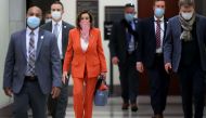 Wearing a scarf over her mouth and nose, Speaker of the House Nancy Pelosi (D-CA) is surrounded by security and staff as she arrives for her weekly news conference during the novel coronavirus pandemic at the U.S. Capitol April 24, 2020 in Washington, DC.