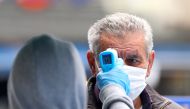 DUZCE, TURKEY - MAY 5: An officer checks the body temperature of a man wearing mask as people continue stay at home as a precaution against coronavirus (Covid-19) pandemic in Duzce, Turkey on May 5, 2020. ( Ömer Ürer - Anadolu Agency 