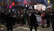 Demonstrators hold signs in front of California Highway Patrol officers during a protest sparked by the death of George Floyd while in police custody on May 29, 2020 in Oakland, California. Justin Sullivan/Getty Images/AFP