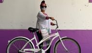 Mexican doctor Yolanda Perez poses after receiving a bicycle from the Biciteka Foundation in Mexico City on May 24, 2020. amid the new coronavirus pandemic. AFP / Rodrigo Arangua 