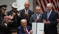U.S. President Donald Trump is applauded by law enforcement leaders surrounding him as he holds up an executive order on police reform after signing it during an event in the Rose Garden at the White House in Washington, U.S., June 16, 2020. REUTERS/Leah 