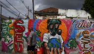A man walks in front of a graffiti of a boy wearing a face mask, amid the coronavirus disease (COVID-19) outbreak in Rio de Janeiro, June 16, 2020. REUTERS/Pilar Olivares