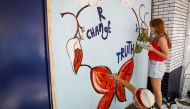 Artist Eileen Duster and her daughter Ave paint a mural on a boarded-up restaurant as part of neighborhood project in the Bowery neighborhood of Manhattan in New York City, New York, U.S., June 17, 2020. Picture taken June 17, 2020. REUTERS/Brendan McDerm