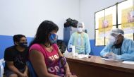 Brazilian indigenous Anita (C) and Nilton of the Marubo ethnic group are notified that they contracted the novel coronavirus by a member of the medical team of the Brazilian Armed Forces at a health post in Atalaia do Norte, Amazonas state, northern Brazi