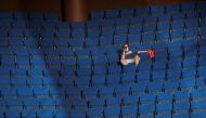 FILE PHOTO: A supporter of U.S. President Donald Trump shoots a video with his mobile phone from the sparsely filled upper decks of the arena as the president addresses his first re-election campaign rally in several months in the midst of the coronavirus