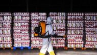 An employee disinfects supplies at a municipal warehouse in Curitiba, Brazil, on June 19, 2020. / AFP / DANIEL CASTELLANO