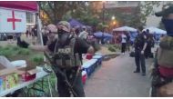 A police officer, wearing a tactical vest, gestures for people to step back after a fatal shooting at Jefferson Square Park, in Louisville, Kentucky, U.S., June 27, 2020 in this still image obtained from social media video. Maxwell Mitchell via REUTERS 