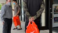In this file photo taken on June 18, 2020, stand in line to get into the Nike Factory store at Queenstown Outlets in Queenstown, Maryland, during the coronavirus pandemic. Nike said on July 22, 2020, it expects to cut jobs as it announced a slew of new ex