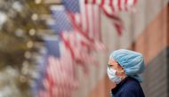 FILE PHOTO: A nurse wearing personal protective equipment watches an ambulance driving away outside of Elmhurst Hospital during the ongoing outbreak of the coronavirus disease (COVID-19) in the Queens borough of New York, U.S., April 20, 2020. REUTERS/Luc
