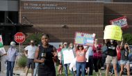 A TV news reporter films a hit in front of supporters of the Cherokee County School District's decision to reopen schools to students during the coronavirus disease (COVID-19) pandemic as they rally outside the district's headquarters, the Dr. Frank R. Pe