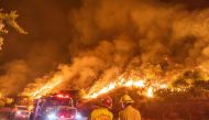 Firefighters battle the smoke and flames from the Ranch Fire in the hills in Azusa, California, on August 14, 2020, 25 miles (40kms) east of Los Angeles. The Los Angeles County Fire Department was alerted to the brush fire at 2:45 pm. By August 13 in the 
