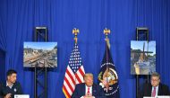 US President Donald Trump with US Attorney General William Barr (R) and Acting Homeland Security Secretary Chad Wolf (L), speaks to officials during a roundtable discussion on community safety, at Mary D. Bradford High School in in Kenosha, Wisconsin on S