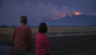 Local residents look at smoke and fire over a hill during wildfires near the town of Medford, Oregon, U.S. September 9, 2020. REUTERS/Carlos Barria
