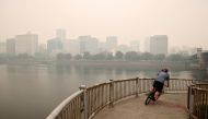 A man rides a bike as smoke from wildfires covers an area near Portland, Oregon, U.S., September 11, 2020. REUTERS/Carlos Barria