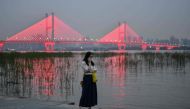 A woman wearing a face mask as a preventive measure against the Covid-19 coronavirus talks on her phone next to the Yangtze River in Wuhan, in China’s central Hubei province on September 25, 2020. / AFP / Hector RETAMAL