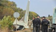 Military and experts work on the place of the Antonov-26 transport aircraft crash at Chuhuiv military air base around 30 kilometers southeast of Kharkiv on September 26, 2020.  AFP / SERGEY BOBOK