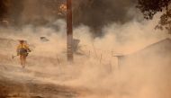 ST HELENA, CALIFORNIA - SEPTEMBER 27: A firefighter walks through smoke as he battles the Glass Fire on September 27, 2020 in Napa, California. Justin Sullivan/AFP
