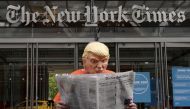 Mike Hisey dressed as U.S. President Donald Trump in a prison jumpsuit reads the New York Times in front of the New York Times office in the Manhattan borough of New York City, New York, U.S., September 28, 2020. REUTERS/Carlo Allegri
