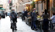 A man rides a bike, as local authorities in the Italian capital Rome order face coverings to be worn at all times out of doors in an effort to counter rising coronavirus disease (COVID-19) infections, in Rome, Italy October 6, 2020. REUTERS/Remo Casilli