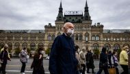 A man wearing a face mask to protect against the coronavirus disease walks on Red Square in front of the GUM department store in central Moscow on October 7, 2020. / AFP / Dimitar DILKOFF
