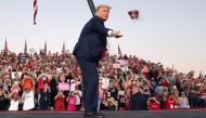 US President Donald Trump throws masks to supporters as he arrives to hold a Make America Great Again rally as he campaigns at Orlando Sanford International Airport in Sanford, Florida, October 12, 2020. AFP / SAUL LOEB