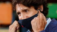FILE PHOTO: Canada's Prime Minister Justin Trudeau removes his face mask before speaking at the 3M's plant in Brockville, Ontario, Canada August 21, 2020. REUTERS/Lars Hagberg/File Photo