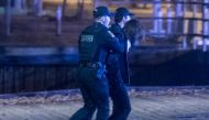 Police officers detain a man near the National Assembly of Quebec, in Quebec City, early on November 1, 2020, after two people were killed and five wounded by a sword-wielding suspect dressed in medieval clothing. AFP / Jordan Proust
