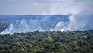 Aerial view showing smoke from a fire billowing from the Amazon rainforest in Oiapoque, Amapa state, Brazil, on the border with French Guiana, on October 31, 2020./ AFP / NELSON ALMEIDA
