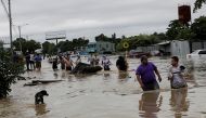 People walk through a flooded street during the passage of Storm Eta, in La Lima, Honduras November 5, 2020. REUTERS/Jorge Cabrera
