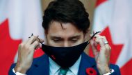 Canadian Prime Minister Justin Trudeau puts on a mask at a news conference held to discuss the country's coronavirus disease (COVID-19) response in Ottawa, Ontario, Canada. November 6, 2020. REUTERS/Patrick Doyle
