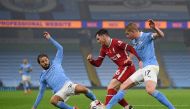 Liverpool's Scottish defender Andrew Robertson (C) gets tackled by Manchester City's Belgian midfielder Kevin De Bruyne (R) and Manchester City's Portuguese midfielder Bernardo Silva (L) during the English Premier League football match between Manchester 