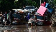 Workers of banana fields come across a flooded road while evacuating the area in El Progreso, Yoro department, Honduras, on November 14, 2020, before the arrival of tropical storm Iota. Less than two weeks after powerful storm Eta killed more than 200 peo