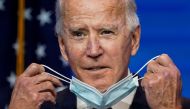 U.S. President-elect Joe Biden removes his face mask to speak about the U.S. economy after attending a briefing in Wilmington, Delaware, U.S., November 16, 2020. REUTERS/Kevin Lamarque 
