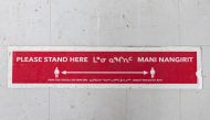 A sign written in English and Inuktitut requesting social distancing to help slow the spread of coronavirus disease (COVID-19) is seen on the floor of a grocery store as the territory of Nunavut enters a two week mandatory restriction period in Iqaluit, N
