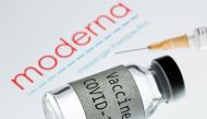 This picture taken on November 18, 2020 shows a syringe and a bottle reading 
