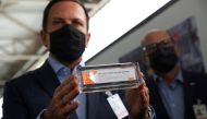 FILE PHOTO: Brazil's Sao Paulo state governor, Joao Doria, and director of Instituto Butantan, Dimas Tadeu Covas, hold boxes of the China's Sinovac vaccine against the coronavirus disease (COVID-19) as a cargo plane containing the vaccines arrives at Sao 