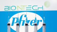 Syringes are seen in front of displayed Biontech and Pfizer logos in this illustration taken November 10, 2020. REUTERS/Dado Ruvic/File Photo