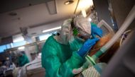 A healthcare worker attends to a COVID-19 coronavirus patient at the Intensive Unit Care of the Povisa Hospital in Vigo, northwestern Spain, on April 16, 2020.  AFP / MIGUEL RIOPA