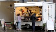 People stand in front The Resident Food Truck snack stall, as the spread of the coronavirus disease (COVID-19) continues, in Zurich, Switzerland December 9, 2020. REUTERS/Arnd Wiegmann