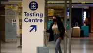 A passenger walks past a testing centre sign in the terminal building of Manchester Airport amid the outbreak of the coronavirus disease (COVID-19) in Manchester, Britain, December 3, 2020. REUTERS/Phil Noble