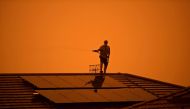 A resident uses a garden hose to wet down the house as high winds push smoke and ash from the Currowan Fire towards Nowra, New South Wales, Australia January 4, 2020. REUTERS/Tracey Nearmy/File Photo/File Photo