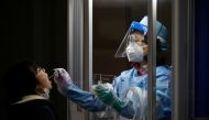 A woman undergoes a coronavirus disease (COVID-19) test at a testing site in Seoul, South Korea, December 13, 2020. REUTERS/Kim Hong-Ji