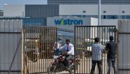People exit from the gate of Wistron, a Taiwanese-run iPhone factory at Narsapura, about 60 km from Bangalore on December 13, 2020. AFP / Manjunath Kiran
