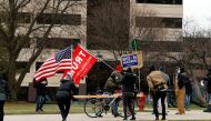 Supporters of President Donald Trump and a supporter of President-elect Joe Biden stand outside the Michigan state capital as the Electoral College votes in Lansing, Michigan on December 14, 2020.  AFP / JEFF KOWALSKY