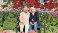 This undated handout picture released by Clarence House on December 16, 2020, shows Britain's Prince Charles, Prince of Wales (L) and Britain's Camilla, Duchess of Cornwall posing for their 2020 Christmas card at Birkhall in Aberdeenshire, Scotland. / AFP