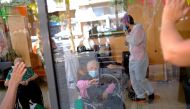 File photo: Josefa Velasco, 94, who overcame the coronavirus disease (COVID-19) and lives in a care home, waves goodbye to her relatives after they talk through a glass front at the Centre Parc nursing home in Barcelona, Spain August 27, 2020. Reuters/Nac